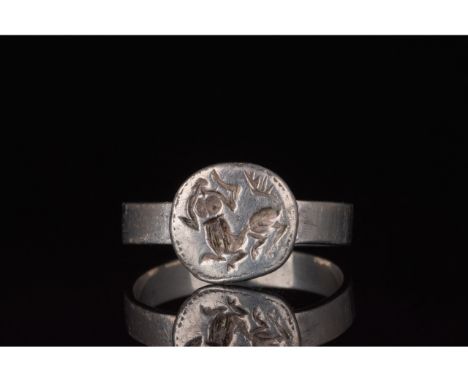 100-300 AD. Roman. Silver  ring with circular hoop and applied round plate bezel featuring an engraved centaur. In Greek and 