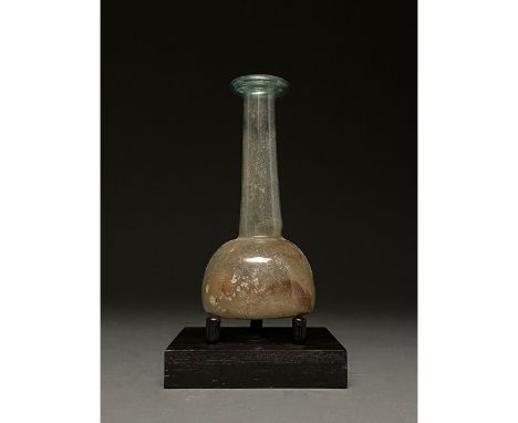 100-300 AD. Roman. Pale blue glass unguentarium with folded, flaring rim, long, slightly flaring neck and bell-shaped body. T