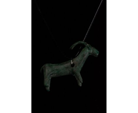 C. 1000 BC. Hallstatt Culture. Cast bronze zoomorphic amulet in the form of a ram with short snout, long curving horns, clear