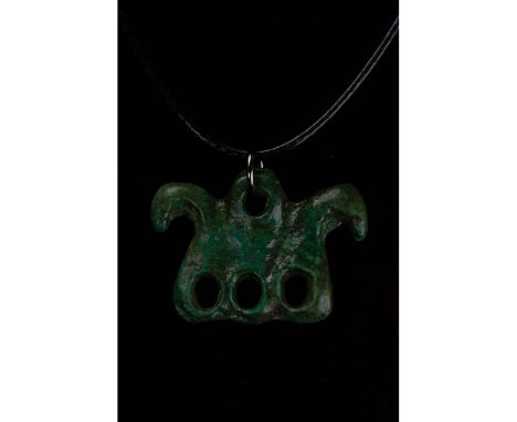 C. 600-800 BC. Bronze Age. Cast bronze zoomorphic amulet comprising an unidentified animal, shown in profile, with a circular