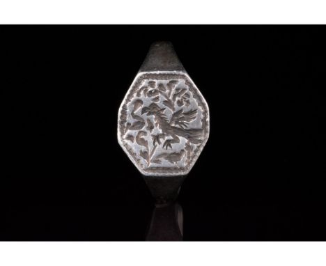 1100-1300 AD, Medieval. A silver ring with a circular hoop and flattened octagonal bezel featuring an incised prancing grypho