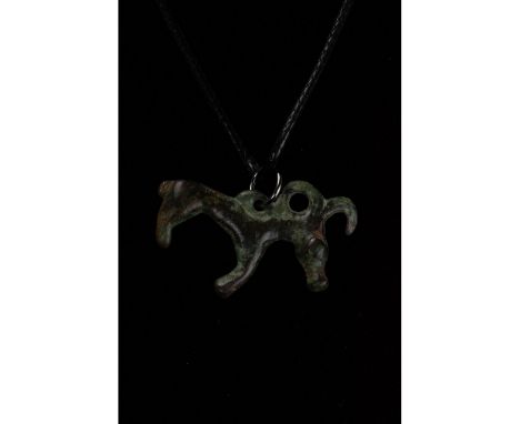 C. 600-800 BC. Bronze Age. Cast bronze zoomorphic amulet comprising an animal, perhaps a horse, shown in profile, with dual c