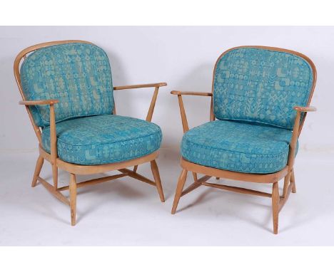 A pair of Ercol light elm stickback elbow chairs, having patterned upholstered cushion backs and seats, each w.69.5cm