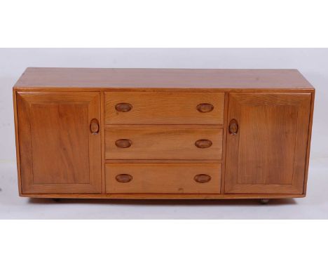 An Ercol blond elm Windsor sideboard, the three central drawers flanked by conforming cupboard doors, raised on roller castor