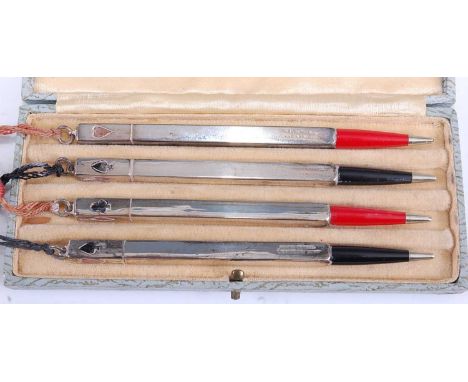A set of four 1930s sterling silver propelling pencils, the terminals each enamel decorated with one of the four card suits, 
