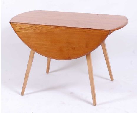 An Ercol light elm dropflap kitchen table, having oval fall leaves, raised on square tapering beech supports, h.73cm, max len