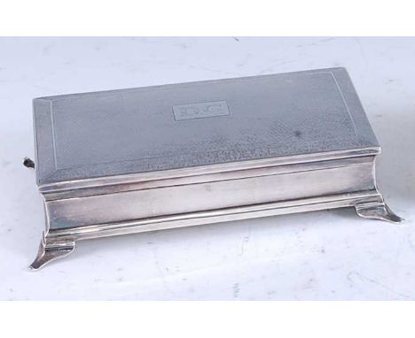 An Art Deco silver table cigarette box, having a slightly domed and engine turned cover with central engraved initials D.C, t