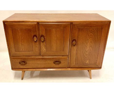 A 1960s Ercol light elm Windsor sideboard, model No.366, with arrangement of three cupboard doors and single lower drawer, h.
