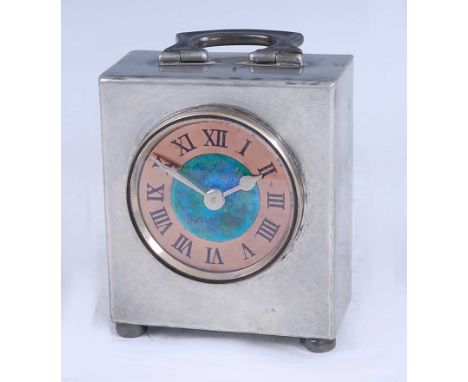 An Art Nouveau Tudric pewter bedside clock, retailed by Liberty &amp; Co, having stylised swing carry handle, with enamel and
