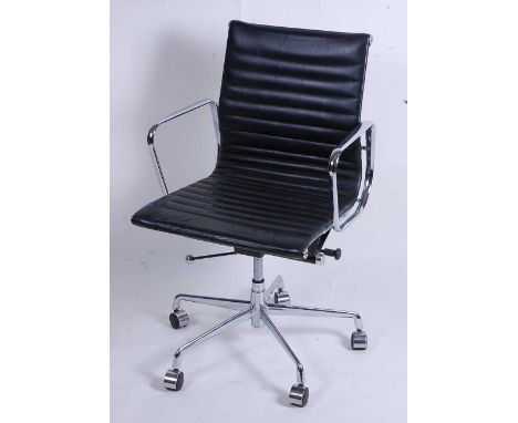 After Charles &amp; Ray Eames - a polished aluminium framed EA108 swivel desk chair, having black leather slung seat, raised 