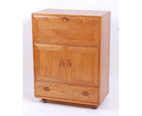 An Ercol light elm Windsor 469 portable drinks cabinet, having fall-front compartment over twin cupboard doors to single long