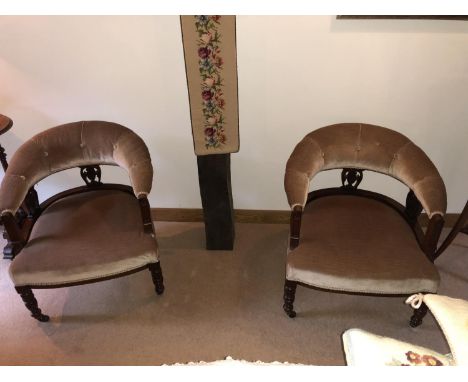 A pair of Victorian mahogany tub chairs, of cresent form upholstered button back with turned legs on castors, upholstered in 