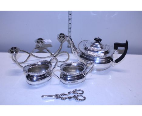 A Viner's silver plated tea service with a pair of plated grape scissors and a plated candelabra 