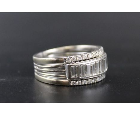 An 18ct white gold half eternity ring, incorporating a row of 14 baguette cut diamonds, flanked by two outer rows of (in tota