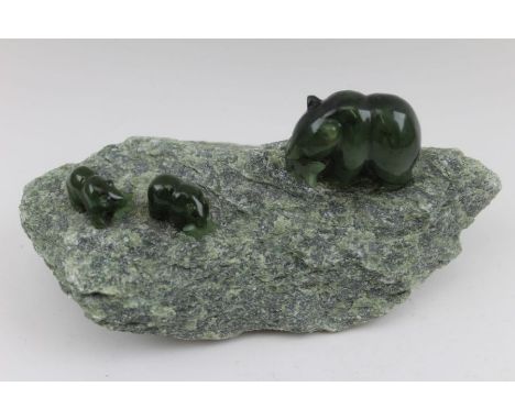 A 20th century Canadian quartz rock, mounted with a jade bear and two cubs, each with a salmon in their mouths