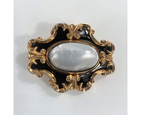 A Victorian yellow metal mourning brooch set with oval mother of pearl and with black enamel surround 