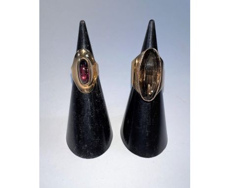 A 9 carat hallmarked gold lady's dress ring with broad shank and inset elongated oval smoky quartz stone; a similar design 9 