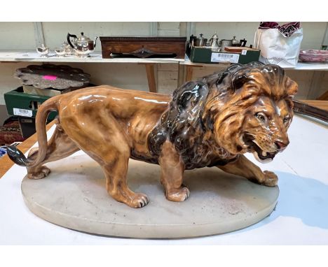 A fine ceramic male lion on marble base 