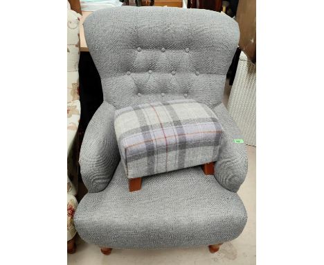 A grey upholstered armchair with button back and a grey tartan footstool 