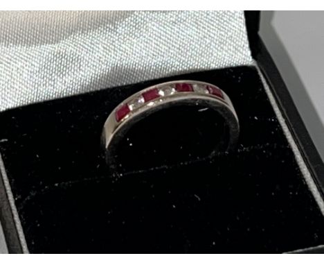 An 18ct Ruby and Diamond channel set half eternity ring.