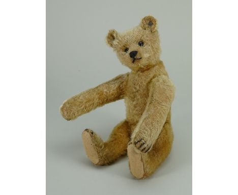 A small Steiff golden mohair Teddy bear, German circa 1909, the straw filled bear with black boot button eyes, stitched nose,