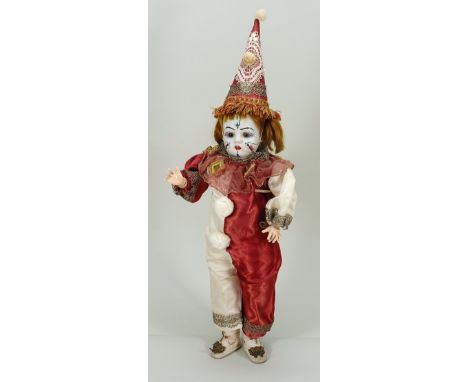 Rare bisque head clown doll, French circa 1900, the white bisque head with fixed brown glass eyes, painted lashes and single 