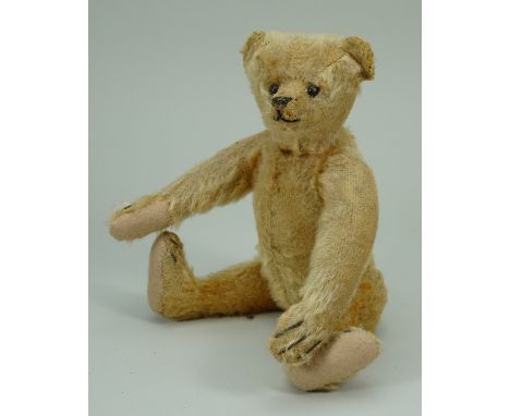 A small Steiff golden mohair Teddy bear, German circa 1909, the straw filled bear with black boot button eyes, stitched nose,