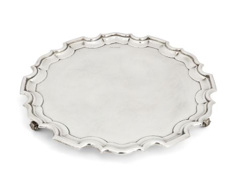 A George VI silver salver with Chippendale border. Walker & Hall, Sheffield, 1950. Of shaped, circular form, the plain base r