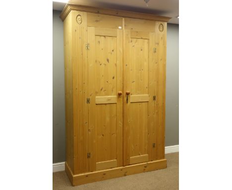 Solid pine double wardrobe, moulded cornice above two twin panel doors, on a plinth base, W147cm, H218cm, D56cm   Condition R