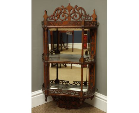 Edwardian walnut wall shelf with mirrored back and two concave shelves with fret work galleries and cresting, turned supports