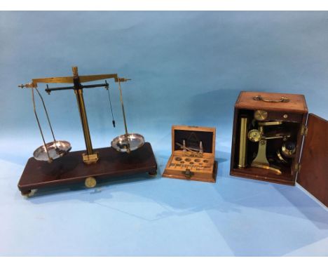 A microscope in fitted case and a set of chemists scales and weights