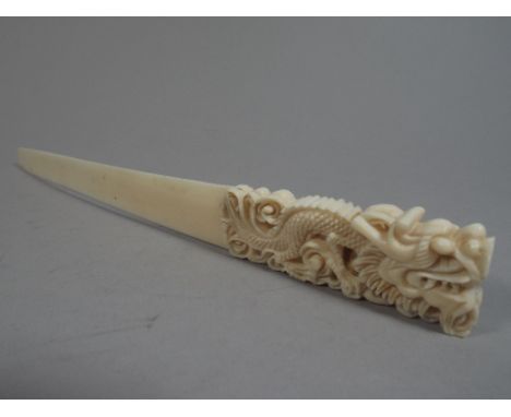 A Japanese Ivory Page Turner. The Handle Carved as a Dragon-in His Mouth is a Loose Carved 'Pearl' 