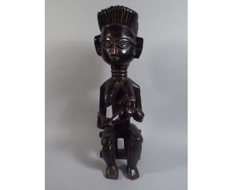An Interesting African Tribal Art Figure Depicting a Nursing Mother Seated on a Stool. 57cm High