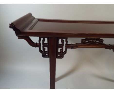 A Good Chinese Padouk Wood Side Table with Carved and Pierced Mouldings and Scroll Ends. 134x39x87cm High 