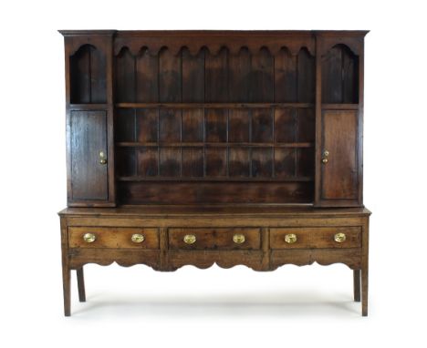 A George III oak Shropshire type high dresser, the boarded rack with three central shelves flanked by an open shelf over a si