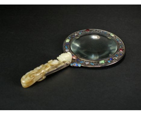 A Chinese jade, hardstone and enamelled silver magnifying glass, Qing Dynasty, the handle mounted with a pale green and russe