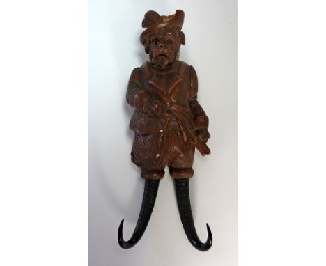 A late 19th century Black Forest wall hanging whip/coat hook in the form of a hunting hound with shooting jacket and shoulder