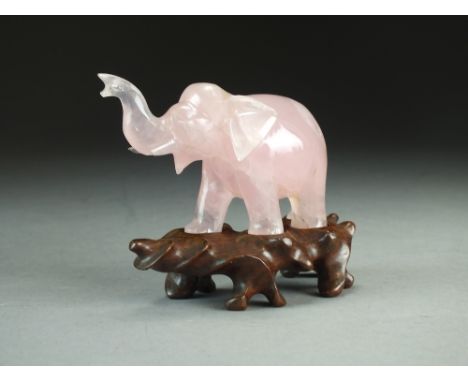 A Chinese rose quartz figure of an elephant, Late Qing/Republic, modelled standing and with trunk raised, with carved hardwoo