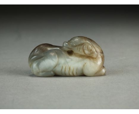 A Chinese grey jade carving of a kylin, Qing Dynasty, modelled recumbent with head facing backward, 5cm long.