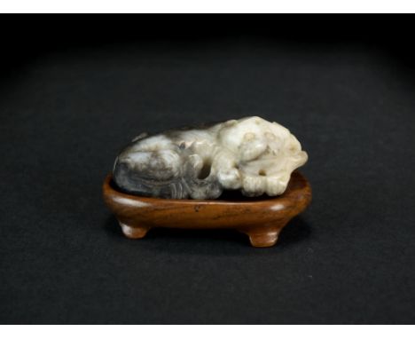 A Chinese grey jade figure of a recumbent bear, Qing Dynasty, with hardwood stand, 5cm long.