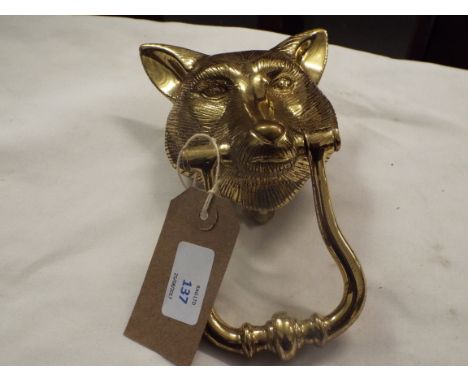 A brass door knocker in the form of a foxes head