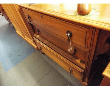 A mid-20thC light oak chest of three graduated panelled drawers raised on bracket feet