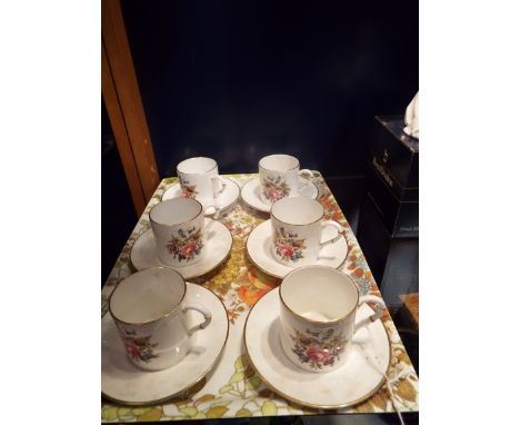 Six Royal Worcester coffee cans and saucers with faux bamboo handles and decorated with floral sprays