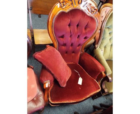 A 20thC mahogany framed French style button-back armchair with floral carved top rail over a serpentine seat and raised on sq