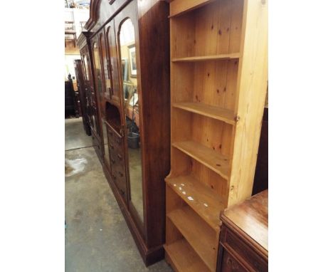 A narrow stripped pine five shelf bookcase