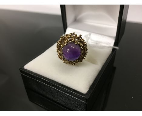 9CT GOLD DRESS RING SET WITH A CABACHON AMETHYST ABOVE A BASKET MOUNT 