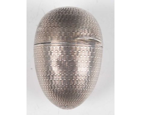 A Victorian silver egg shaped nutmeg grater with engine turned decoration, the hinged lid revealing a pierced hinged grater, 