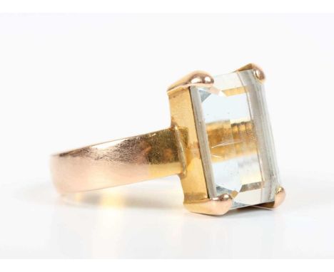 A gold ring, claw set with a large cut cornered rectangular step cut aquamarine, detailed ‘22C’, weight 8.7g, aquamarine weig