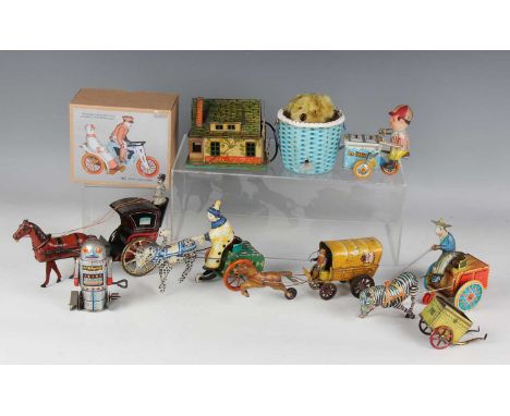 A group of tinplate clockwork toys, including a horsedrawn carriage with gilded spoked wheels, three other horsedrawn carts, 