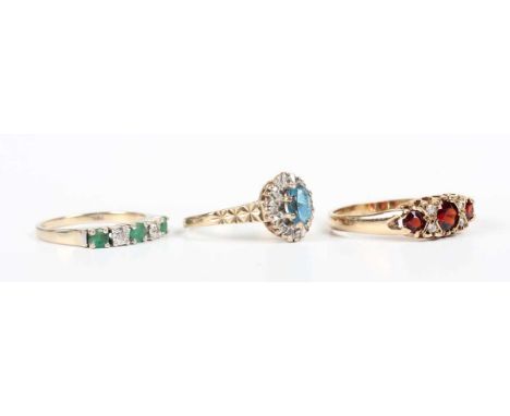 An 18ct gold, emerald and diamond five stone ring, mounted with three circular cut emeralds alternating with two circular cut